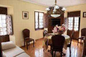 a dining room with a table with flowers on it at La torrevia2 in Santillana del Mar