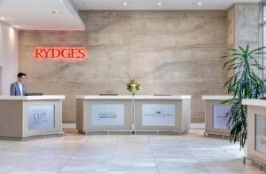 a man standing at a reception desk in a lobby at Rydges Auckland in Auckland