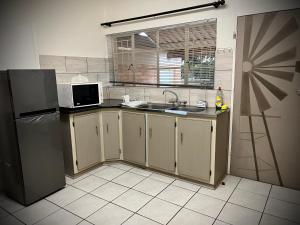 a kitchen with a sink and a refrigerator at Lemon Rose Guest House in Virginia