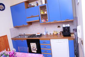 a kitchen with blue cabinets and a stove top oven at B&B Al Porto in Marta