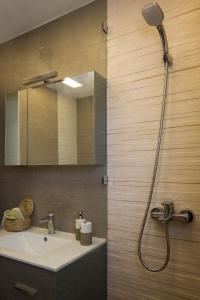 La salle de bains est pourvue d'un lavabo et d'une douche. dans l'établissement ELEGANT BEACH HOUSE, à Artemi