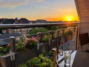 a balcony with a view of a sunset at Private Two Bedroom Residence in Southbourne - Private Parking - Off the High Street - Minutes Away from the Beach in Bournemouth