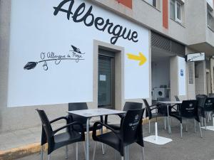 un grupo de mesas y sillas frente a una tienda en Hostel & Rooms O Albergue da Meiga, en Padrón