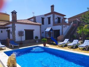 a swimming pool in front of a house at Alojamientos Rurales La Esperanza in Arriate