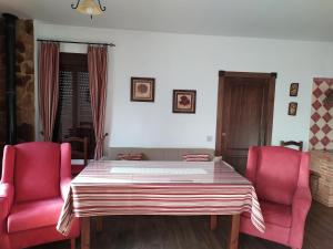 a table and two pink chairs in a room at Alojamientos Rurales La Esperanza in Arriate