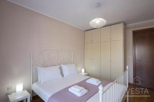 a bedroom with a white bed with white pillows at Park View City Apartment, Vesta Philoxenia in Thessaloniki