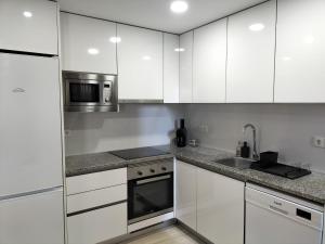 uma cozinha com armários brancos e um lavatório em Casa da Alfândega em Vila do Conde em Vila do Conde