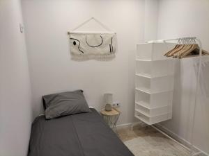 ein Schlafzimmer mit einem Bett und einer Tasche, die an der Wand hängt in der Unterkunft Casa da Alfândega em Vila do Conde in Vila do Conde