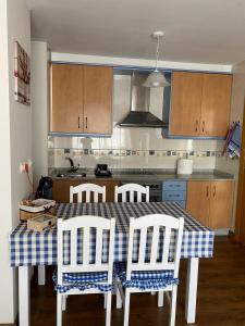 a kitchen with a table with four chairs and a kitchen with a stove at Santiaguiño in Padrón