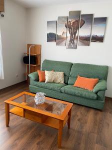 a living room with a green couch and a coffee table at Santiaguiño in Padrón