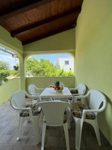 a white table and chairs on a patio at Pomerino Apartmans in Pomer