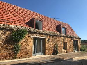 圣西普里安Gîte du Meynet的一座红色屋顶的古老石头建筑