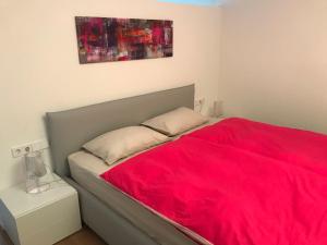 una camera con un letto con una coperta rossa di Casa Sciliar centro paese PINK a Fié allo Sciliar