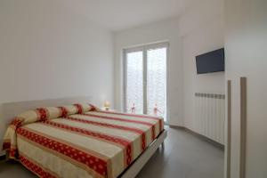 アルバ・アドリアティカにあるPalazzina Romani-Romani Holidays Apartmentsの白いベッドルーム(ベッド1台、テレビ付)