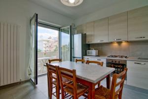 アルバ・アドリアティカにあるPalazzina Romani-Romani Holidays Apartmentsのキッチン(テーブル、椅子付)、窓付きのキッチン
