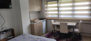 a small kitchen with a table and chairs and a window at Apartment Bućić in Zlatibor