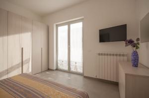 アルバ・アドリアティカにあるPalazzina Romani-Romani Holidays Apartmentsの白い部屋(ベッド1台、テレビ付)