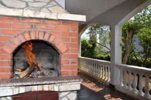 a brick oven with a fire inside of it at Family Holiday house - 50 m to the beach! in Kožino