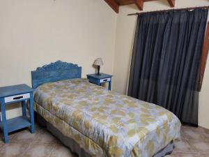 1 dormitorio con 1 cama, 2 mesas y una ventana en Munzenmayer Servicios en Catriel