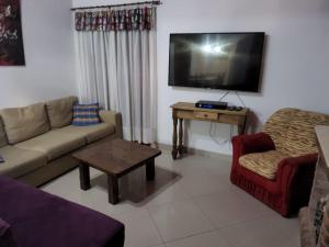 sala de estar con sofá, mesa y TV en Munzenmayer Servicios en Catriel