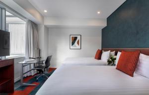 a hotel room with two beds and a tv at Rydges Auckland in Auckland