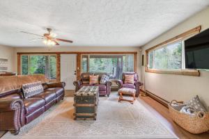 uma sala de estar com mobiliário de couro e uma televisão de ecrã plano em Riverfront Retreat at Lavender Lake em Pine Glen