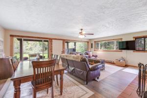 ein Wohnzimmer mit einem Tisch und einem Sofa in der Unterkunft Riverfront Retreat at Lavender Lake in Pine Glen