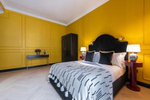 a bedroom with a large bed with yellow walls at The Couper Sant'Andrea in Milan
