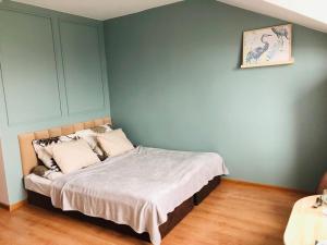 1 cama en un dormitorio con una pared azul en Bałtycki Zakątek en Władysławowo