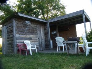 einer Gruppe von Stühlen und einem Tisch vor einer Hütte in der Unterkunft camping chez l'habitant in Noyal-Muzillac