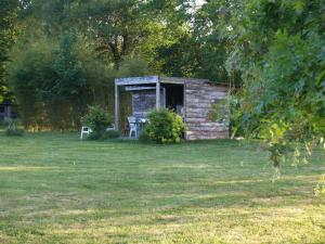 eine Blockhütte mit einem Tisch und einem Stuhl auf einem Feld in der Unterkunft camping chez l'habitant in Noyal-Muzillac