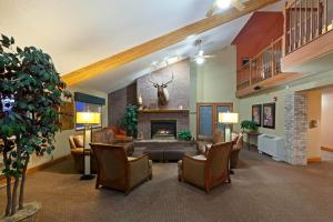 a living room with couches and a fireplace at AmericInn by Wyndham Valley City Conference Center in Valley City