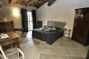 Le Case della Saracca في مونفورتي دالبا: غرفة نوم بسرير وطاولة في غرفة