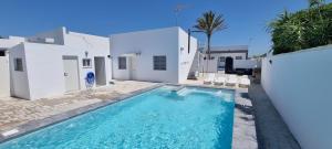 a swimming pool in front of a white house at Casa Las Marismas in Barbate