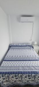 a bed in a room with a blue and white comforter at Casa Las Marismas in Barbate +27 photos