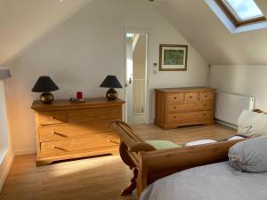 a bedroom with a bed and a dresser and a window at Coach house Harrogate in Harrogate
