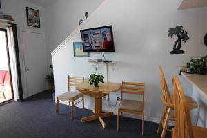 Habitación con mesa, sillas y TV. en Sugar Beach 355 condo, en Gulf Shores
