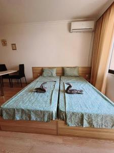 two beds in a room with two ducks on them at Lovely studio apartment on the beach in Burgas City