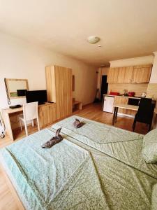 a bedroom with a large bed with two animals on it at Lovely studio apartment on the beach in Burgas City