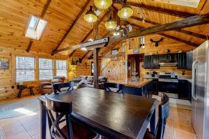 eine Küche und ein Esszimmer mit einem großen Holztisch in der Unterkunft Little Log Cabin in the Woods in The Highlands