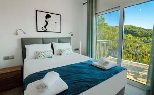 a bedroom with a bed and a large window at Natura Luxury Suites Parga in Parga