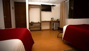 una camera con due letti e una cucina con tavolo di Hotel Kapac Inn-San Blas a Cuzco