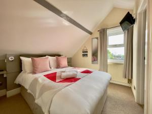 1 dormitorio con 1 cama grande con almohadas rosas en The Hedley Townhouse, en Bournemouth