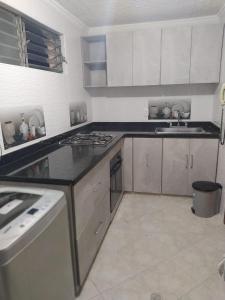 uma cozinha com armários brancos e um forno com placa de fogão em Apartamento Cañaveral em Floridablanca