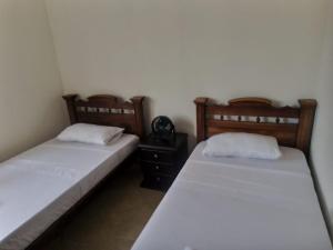 duas camas sentadas uma ao lado da outra num quarto em Apartamento Cañaveral em Floridablanca