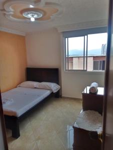 1 dormitorio con cama y ventana en Apartamento Cañaveral, en Floridablanca