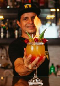 a man is holding a drink in a bar at Hospedaje Garcilazo in Yurimaguas