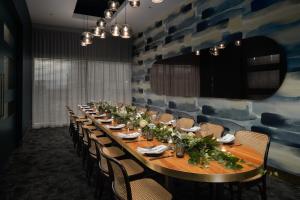 a long table in a room with chairs and a wall at Rydges Auckland in Auckland