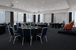 a conference room with tables and chairs and a room with tables and chairs at Rydges Auckland in Auckland