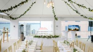a wedding venue with white tables and chairs and flowers at Rydges Auckland in Auckland